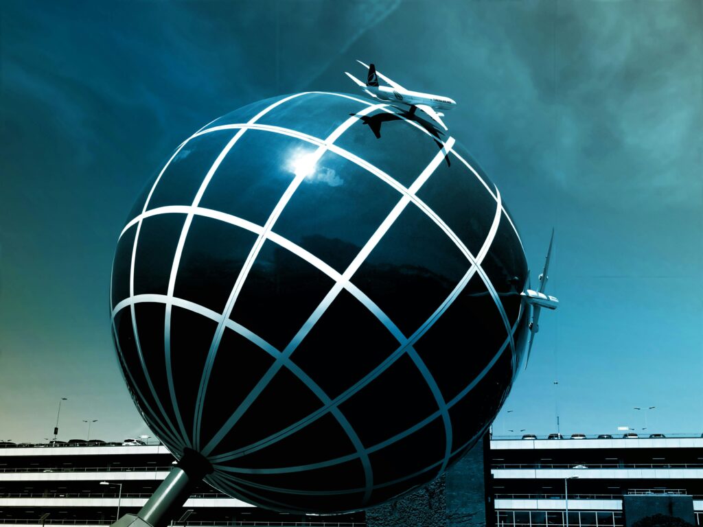 Large spherical structure with airplane models against a clear sky.
